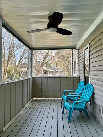 a balcony with wooden floor table and chairs