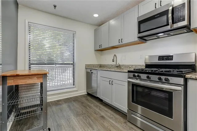 a kitchen with stainless steel appliances a stove microwave and cabinets
