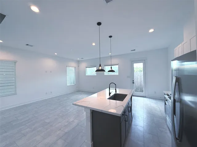 a kitchen with a sink a refrigerator and chairs