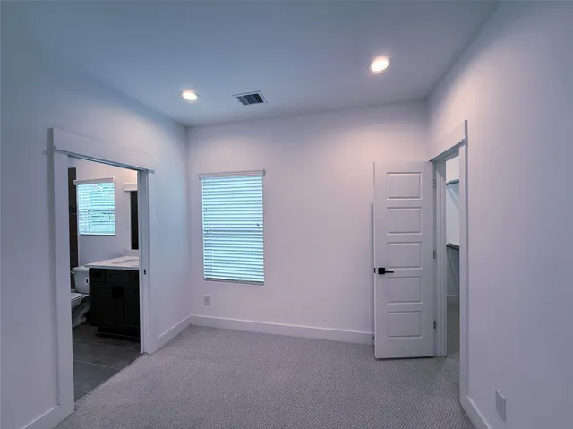 an empty room with an entryway and windows