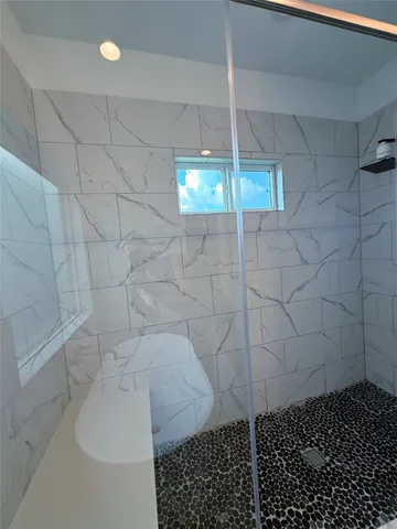 a bathroom with a bathtub shower sink and mirror