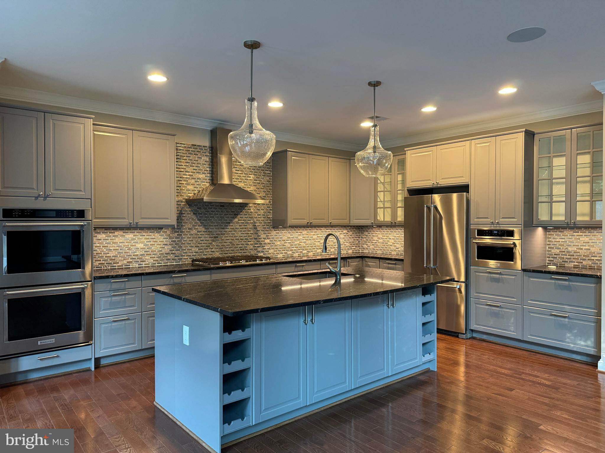 7702 Trammell Road Annandale, VA 22003 - Photo 22 of 68 a kitchen with stainless steel appliances granite countertop a sink a stove and a wooden floor