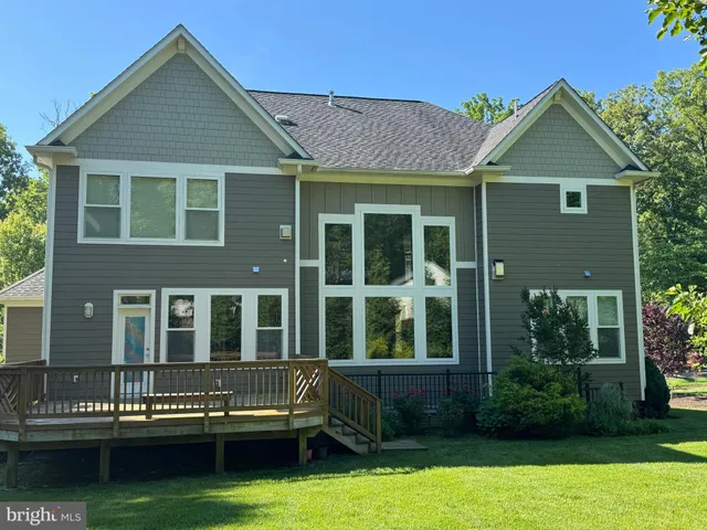 a front view of a house with garden and trees