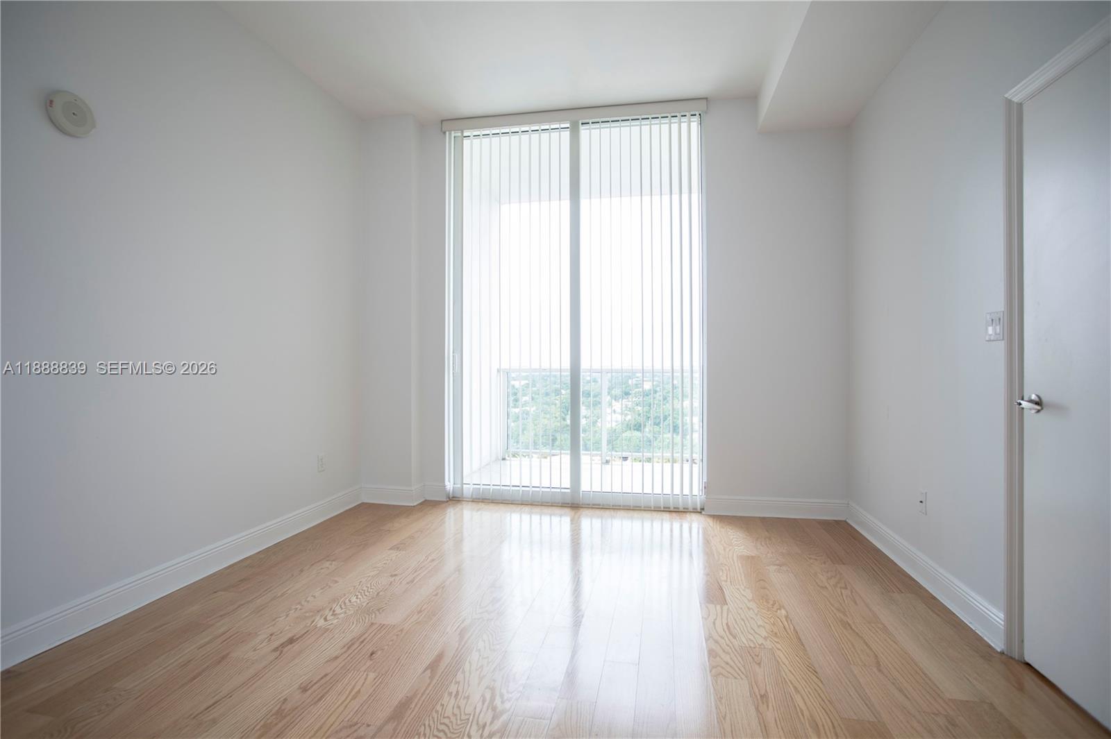 2525 Southwest 3rd Avenue, Unit 1106 Miami, FL 33129 - Photo 12 of 36 an empty room with wooden floor and windows