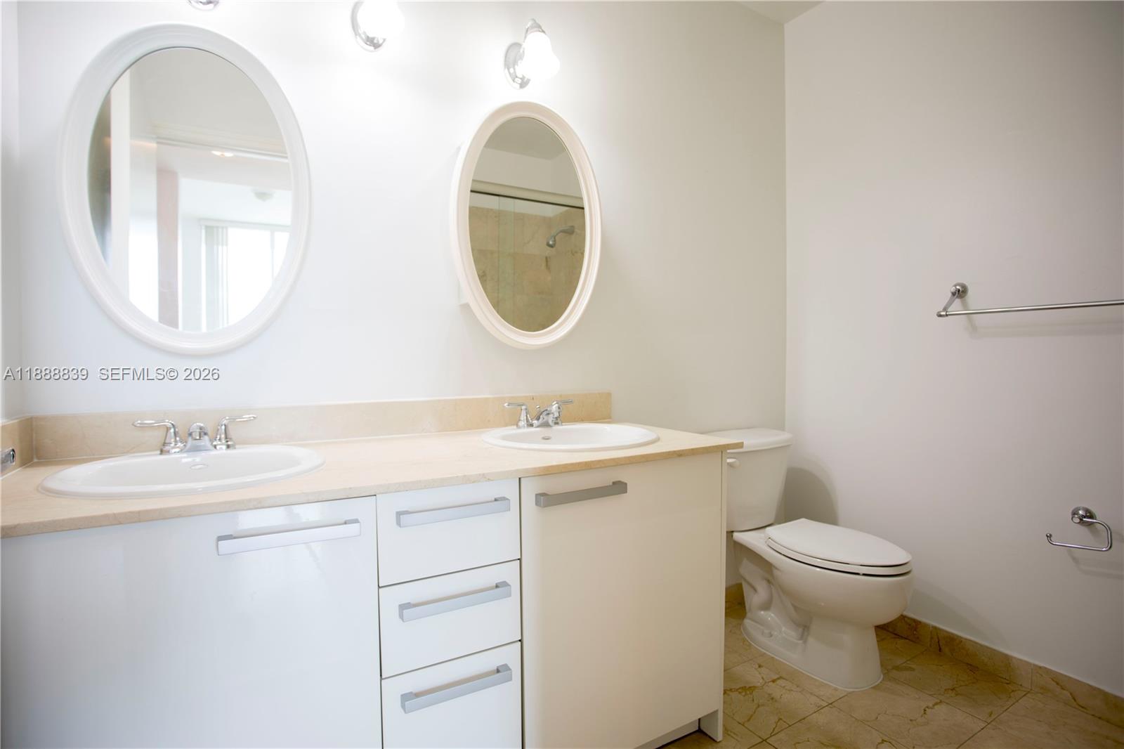 2525 Southwest 3rd Avenue, Unit 1106 Miami, FL 33129 - Photo 16 of 36 a bathroom with a granite countertop toilet a sink and a mirror