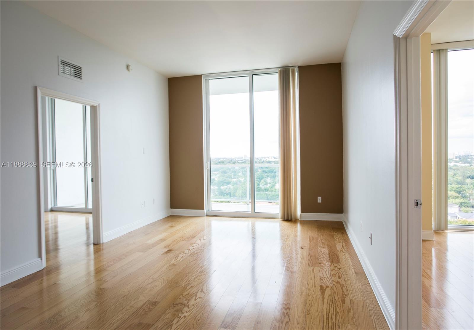 2525 Southwest 3rd Avenue, Unit 1106 Miami, FL 33129 - Photo 6 of 36 a view of an empty room with wooden floor and a window