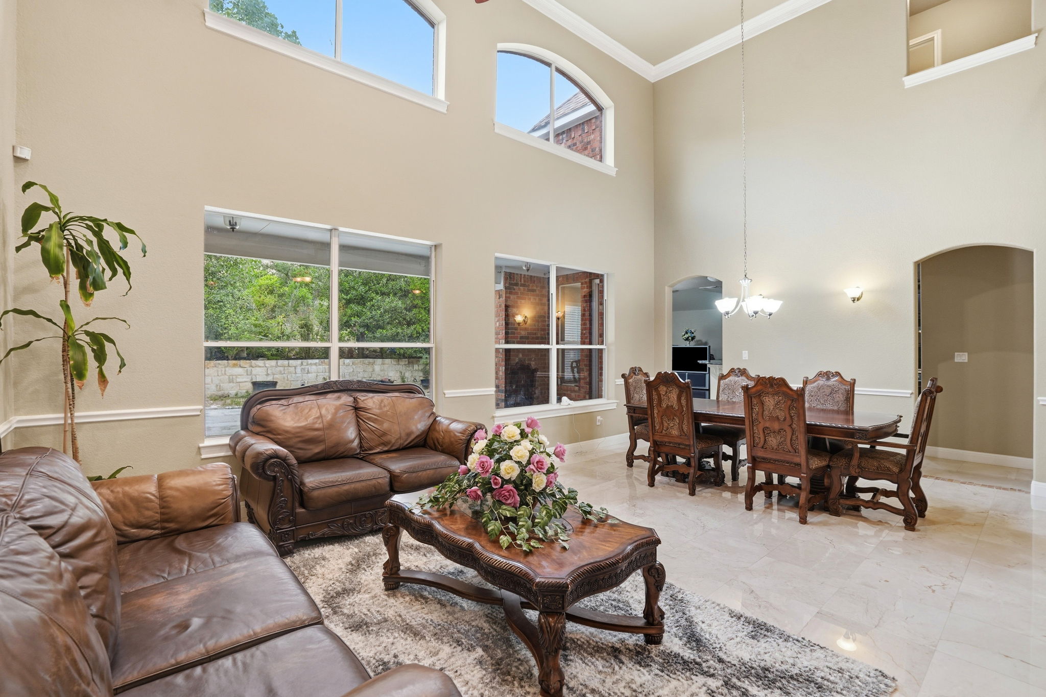 222 Vailco Lane Austin, TX 78738 - Photo 11 of 39 Spacious living area featuring high ceilings, upper transom windows, crown molding, and large format tile flooring