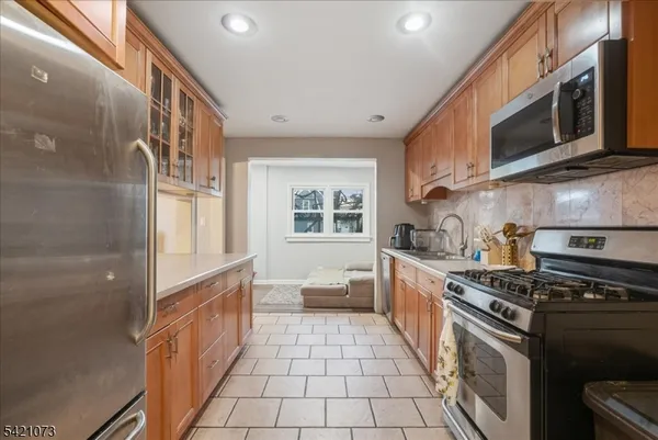 a large kitchen with stainless steel appliances granite countertop a stove and a sink