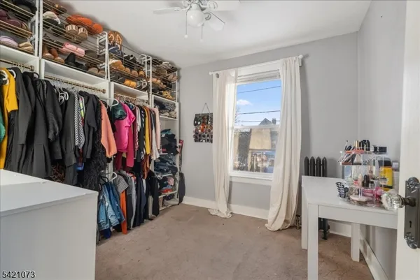 a view of walk in closet with clothes and shoes