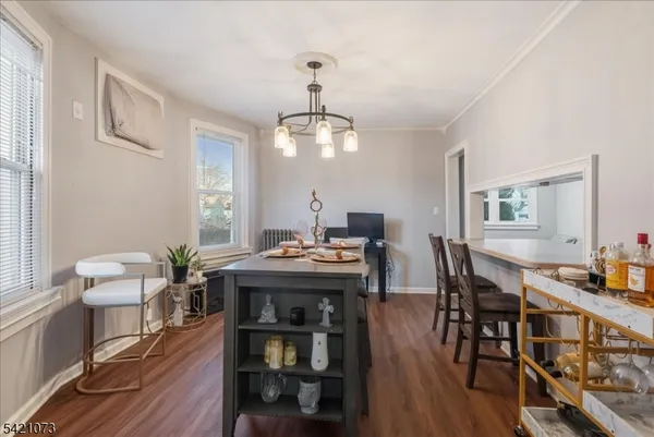 a view of a dining room with furniture a chandelier and wooden floor