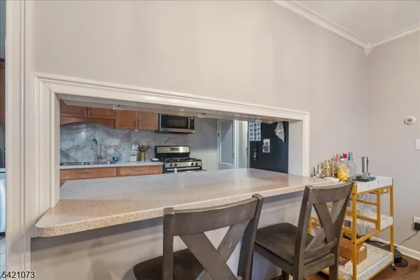 a kitchen with stainless steel appliances a dining table and chairs