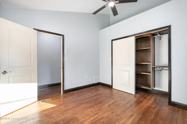 a view of empty room with wooden floor