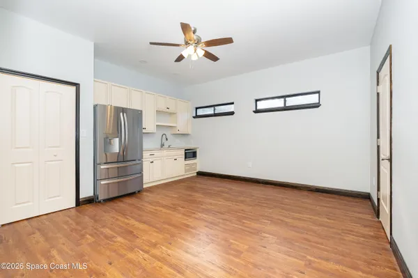 a view of a kitchen with a sink and refrigerator