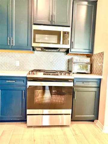 a kitchen with stainless steel appliances granite countertop a sink and a microwave