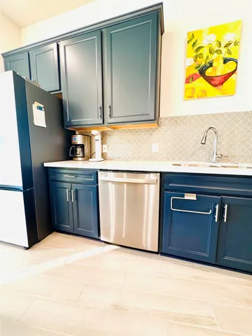 a kitchen with stainless steel appliances kitchen island granite countertop a refrigerator and a stove top oven