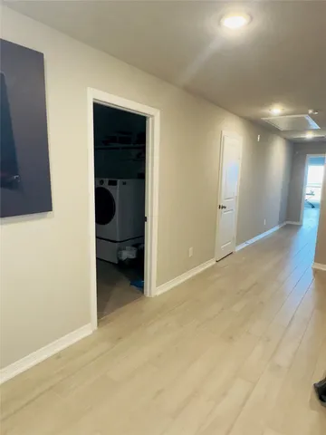 a utility room with dryer washer and a view of living room