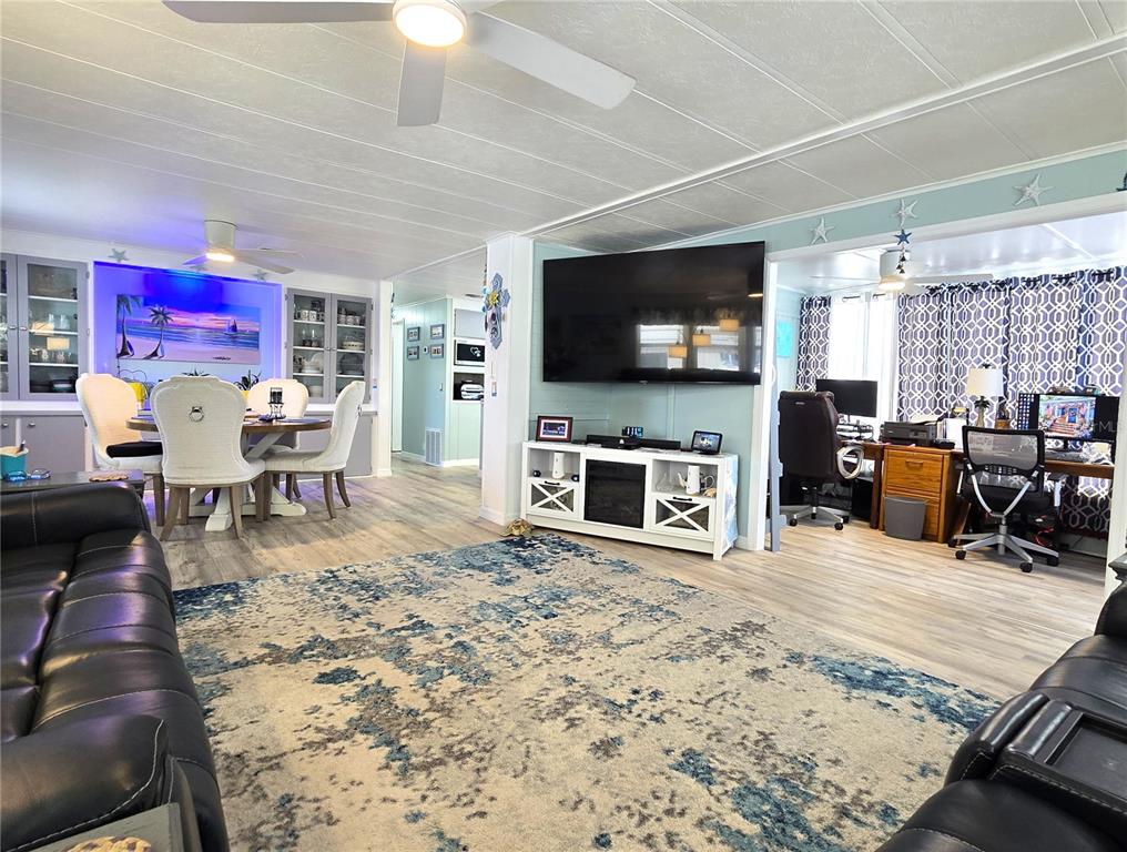 5619 Bayshore Road, Unit 435 Palmetto, FL 34221 - Photo 2 of 56 a living room with furniture a flat screen tv and a fireplace