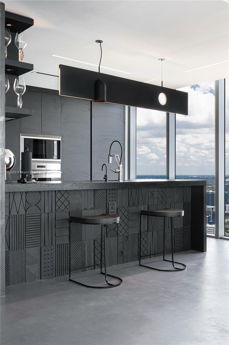 788 Northeast 23rd Street, Unit 4102 Miami, FL 33137 - Photo 8 of 41 a kitchen with kitchen island a counter space a sink a window and stainless steel appliances