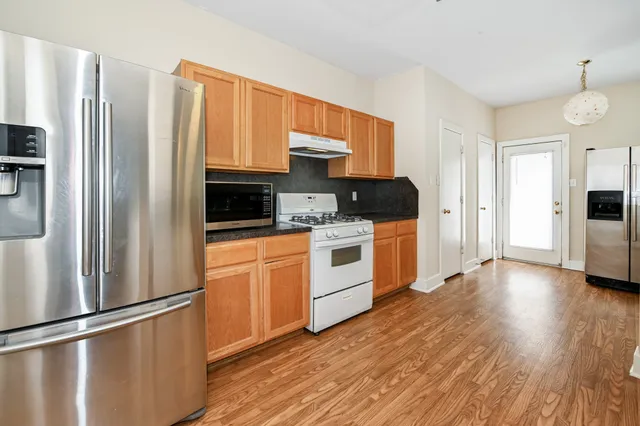 a kitchen with stainless steel appliances a refrigerator sink and microwave