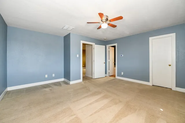 an empty room with a window and a fan