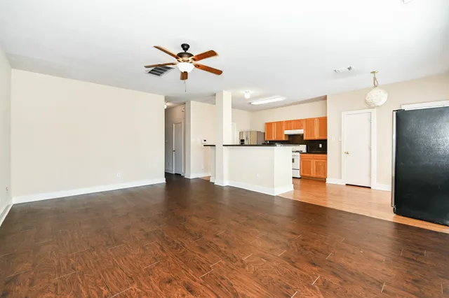 a view of a kitchen with a sink refrigerator and wooden floor