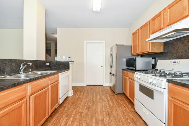 a kitchen with a sink stove top oven and refrigerator