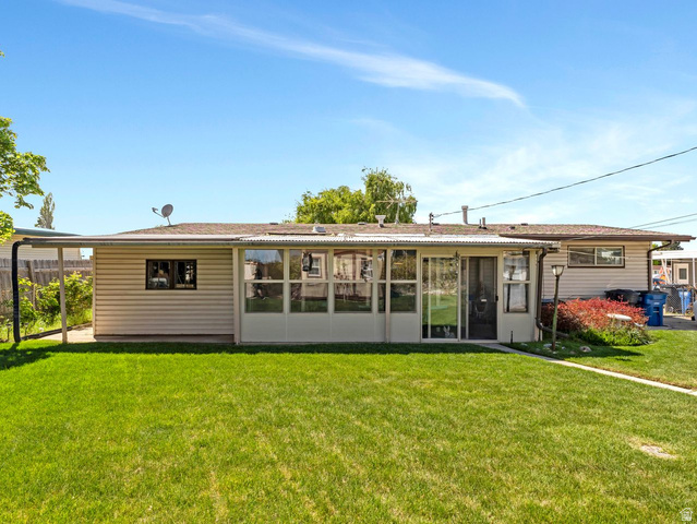 1502 North 475 West Sunset, UT 84015 - Photo 19 of 23 Expansive rear yard featuring a manicured lawn, an enclosed patio, and an extended covered patio
