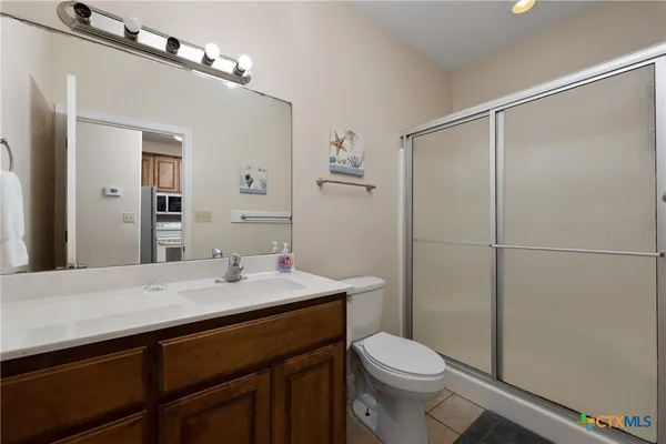 a bathroom with a sink a toilet a mirror and shower