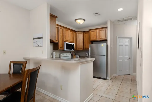 a kitchen with refrigerator cabinets and wooden floor