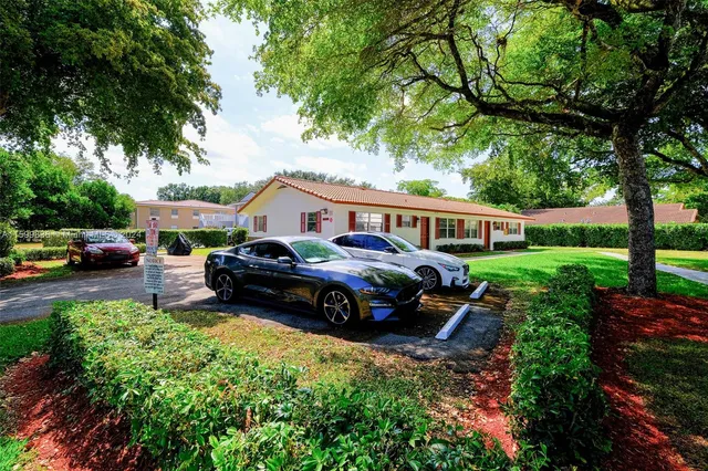 a front view of a house with a garden and tree