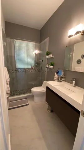a bathroom with a double vanity sink toilet and shower