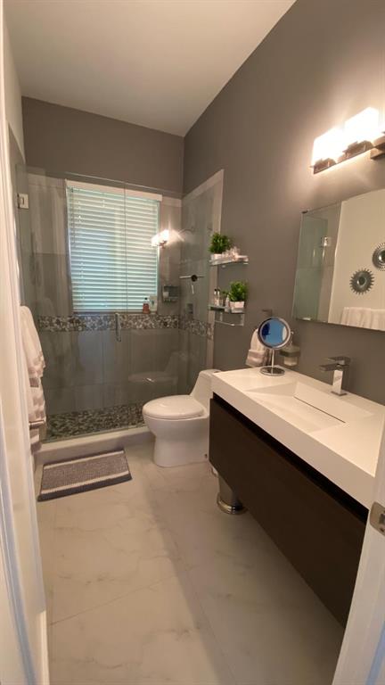 830 Bailey Street Boca Raton, FL 33487 - Photo 15 of 24 a bathroom with a double vanity sink toilet and shower