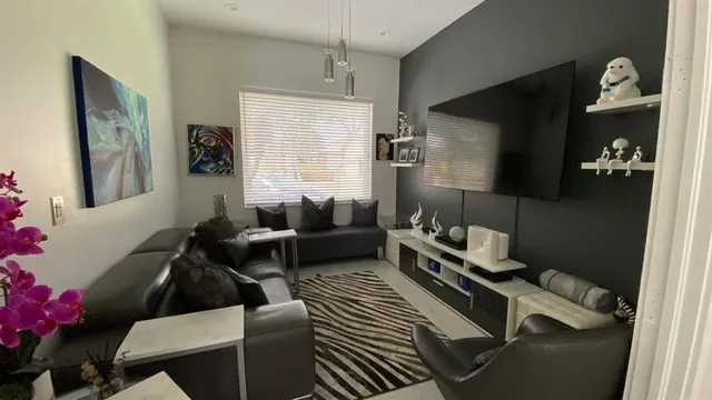 a living room with furniture wooden floor and a flat screen tv