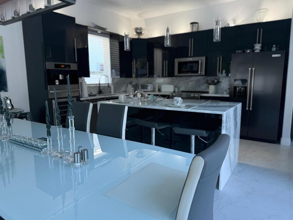 830 Bailey Street Boca Raton, FL 33487 - Photo 8 of 24 a kitchen with stainless steel appliances kitchen island granite countertop a sink refrigerator and cabinets