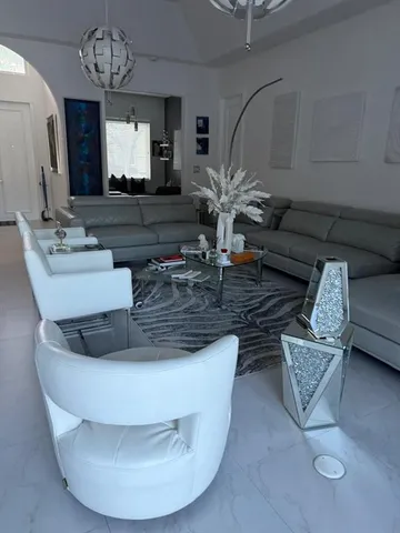 a living room with furniture and a chandelier