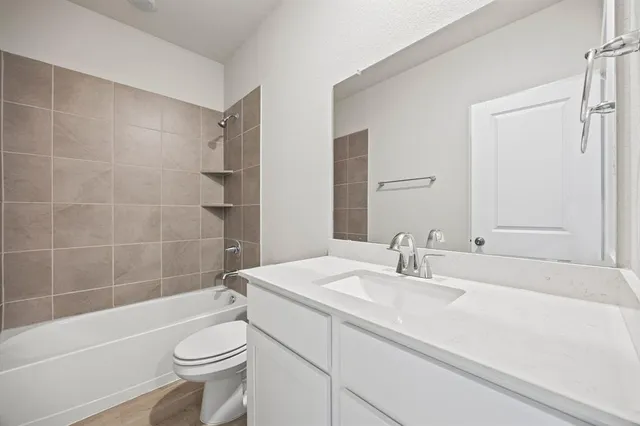 a bathroom with a sink a toilet a mirror a bathtub and shower