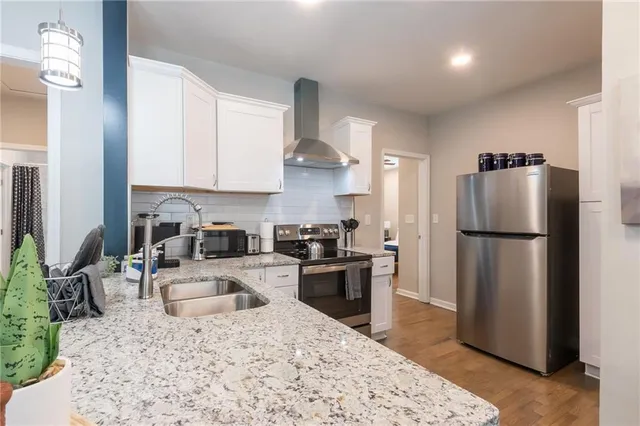 a kitchen with granite countertop a refrigerator stove and sink