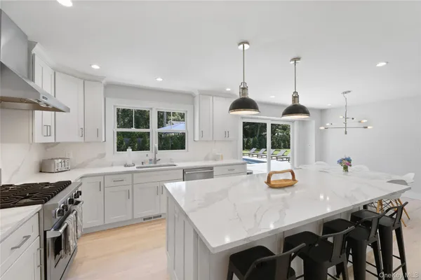 a kitchen with a sink a stove and chairs
