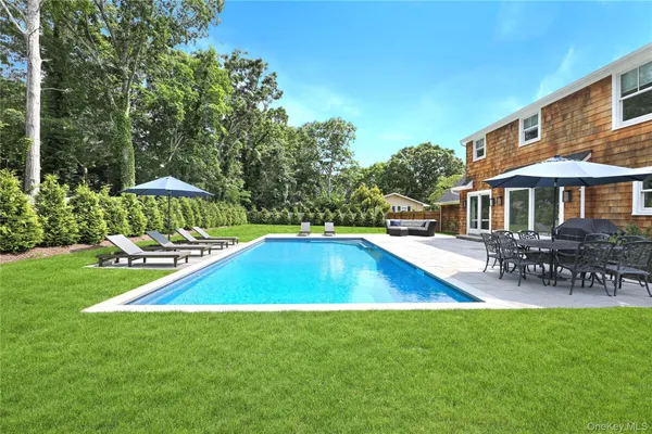 a view of a house with swimming pool and sitting area