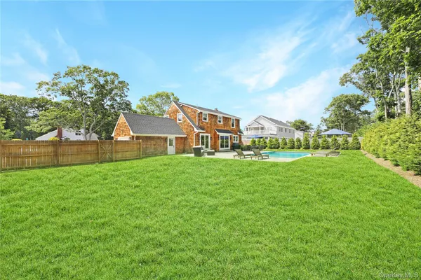 a view of a house with garden and a trees