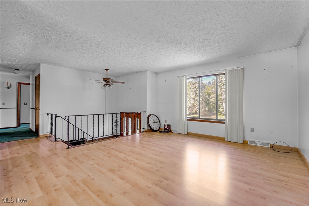 123 Boulder Ridge Place Painesville, OH 44077 - Photo 17 of 28 Spare room featuring a textured ceiling, light wood finished floors, and ceiling fan