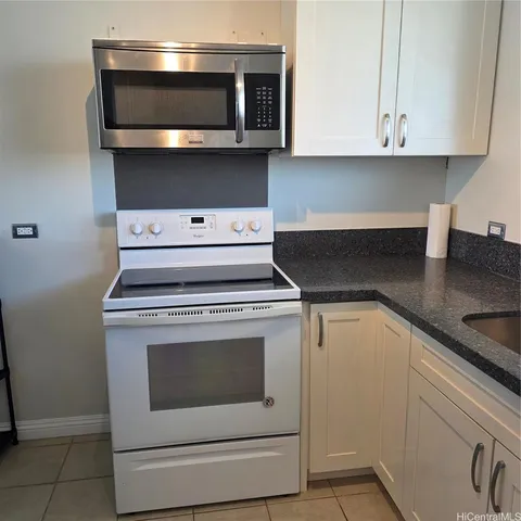 a kitchen with a stove and white cabinets