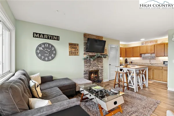 a living room with furniture a flat screen tv and a kitchen view