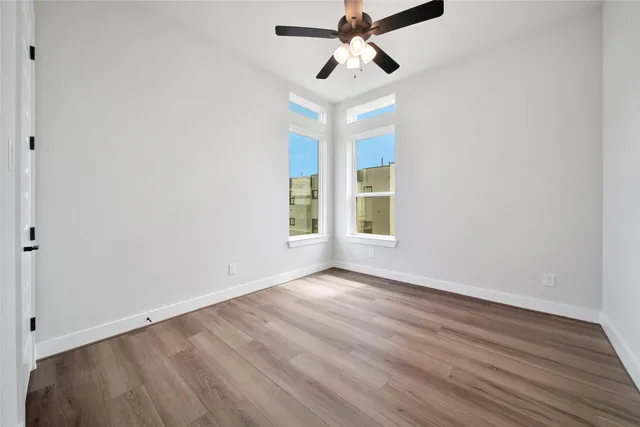 a view of room with hardwood floor and ceiling fan