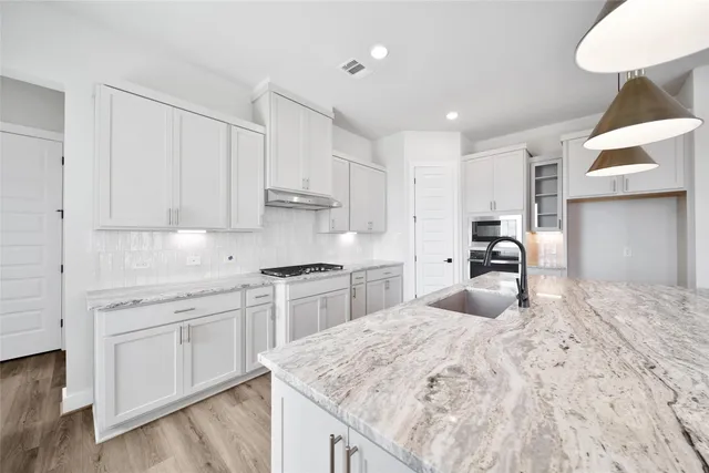 a kitchen with granite countertop white cabinets and white appliances