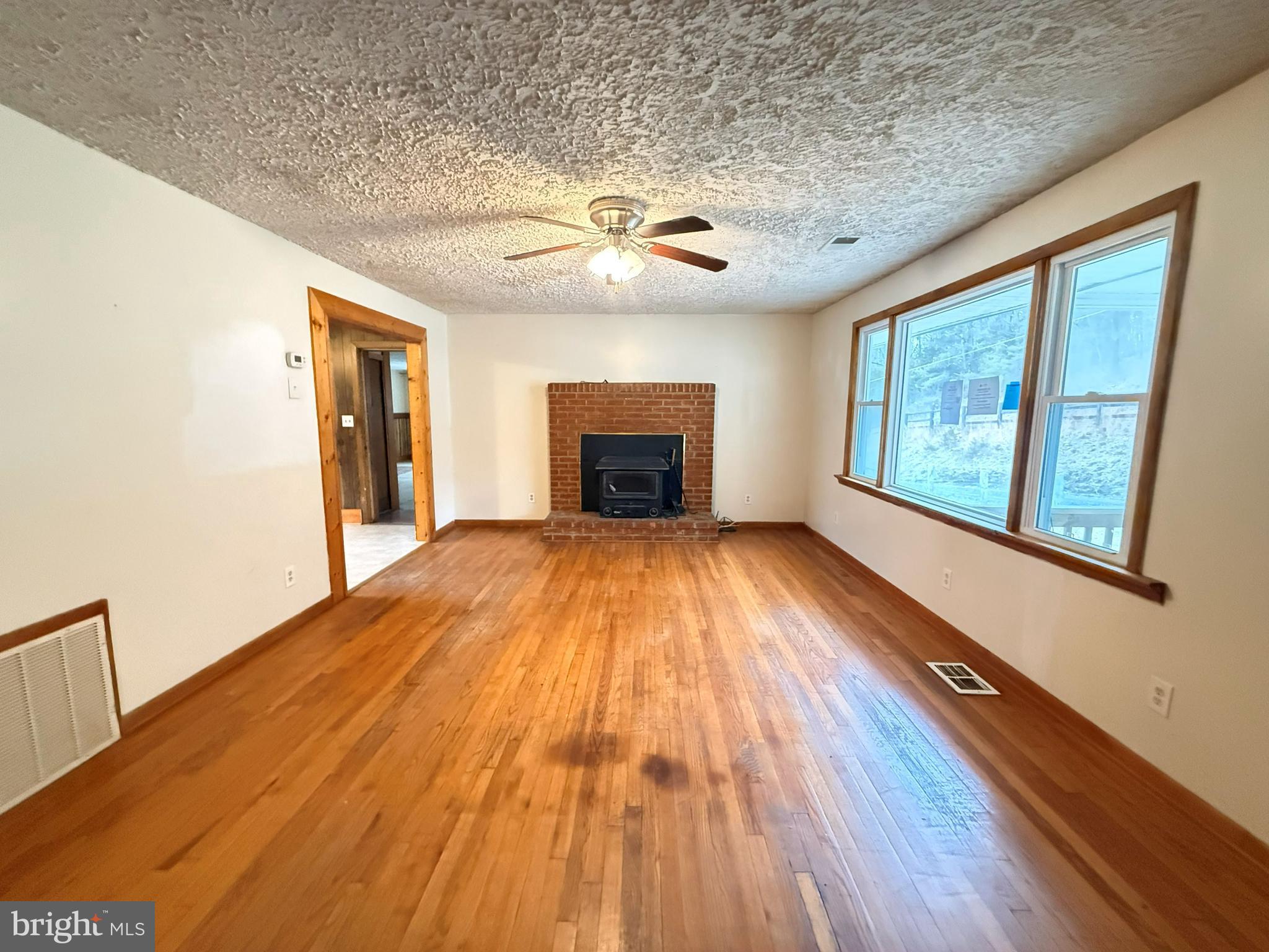 82 Broad Run Road Bentonville, VA 22610 - Photo 6 of 21 a view of empty room with wooden floor and fireplace