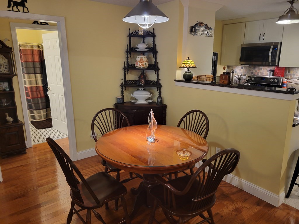 46 Evergreen Road, Unit 210 Leeds, MA 01053 - Photo 17 of 34 a dining room with furniture and wooden floor