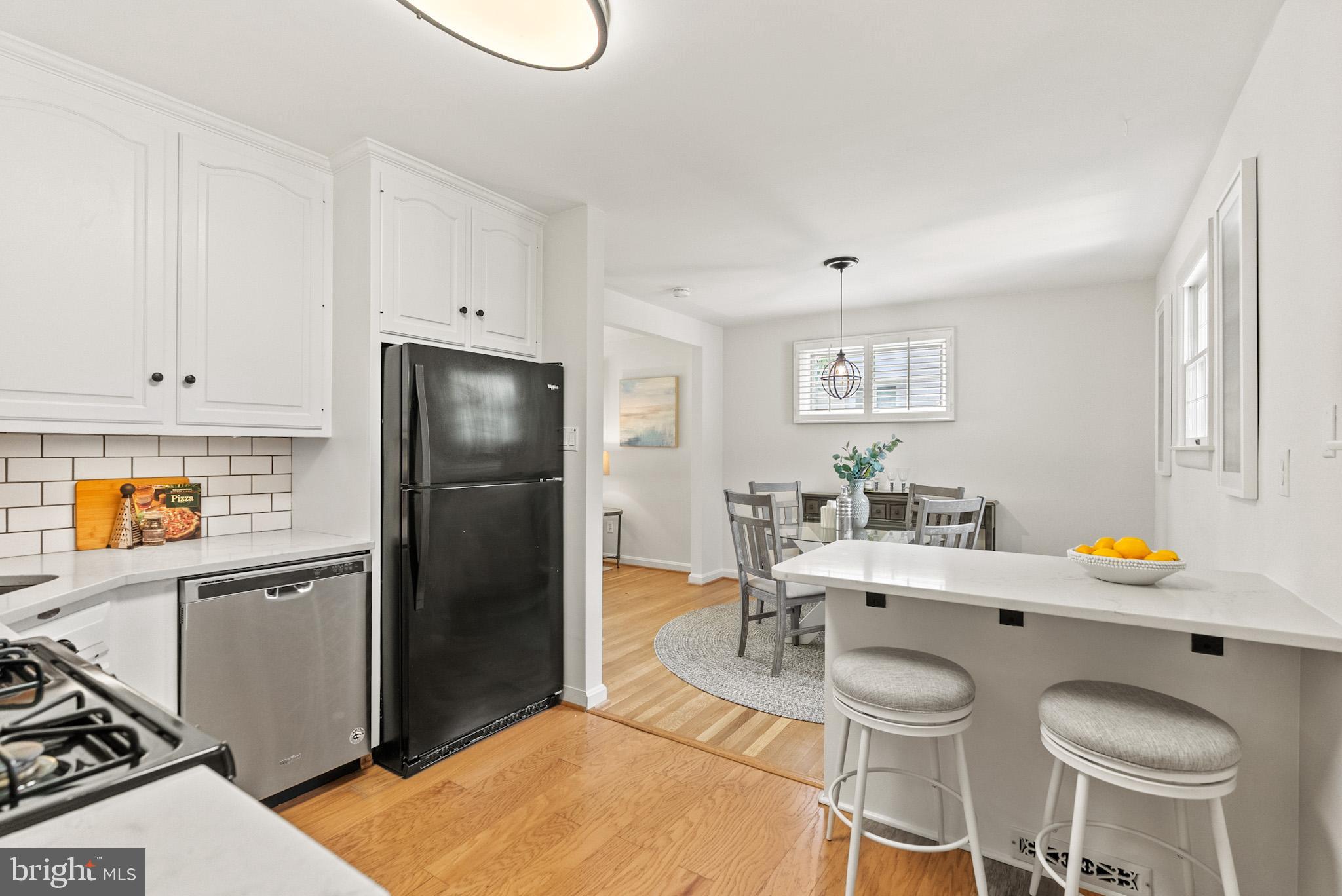 4703 Wyaconda Road Rockville, MD 20852 - Photo 12 of 40 a kitchen with stainless steel appliances granite countertop a refrigerator a sink a stove and white cabinets