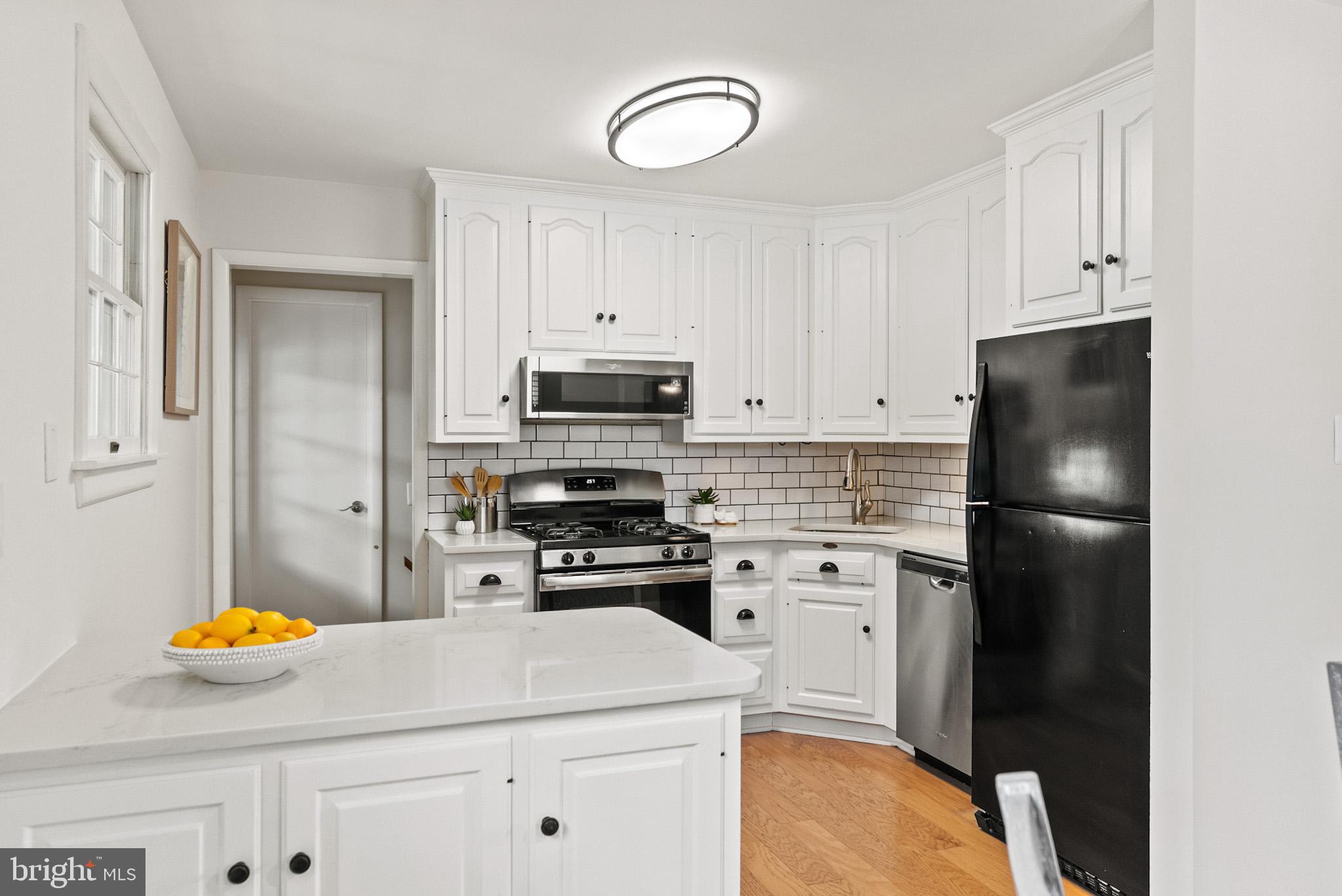 4703 Wyaconda Road Rockville, MD 20852 - Photo 13 of 40 a kitchen with a sink a stove a refrigerator and cabinets