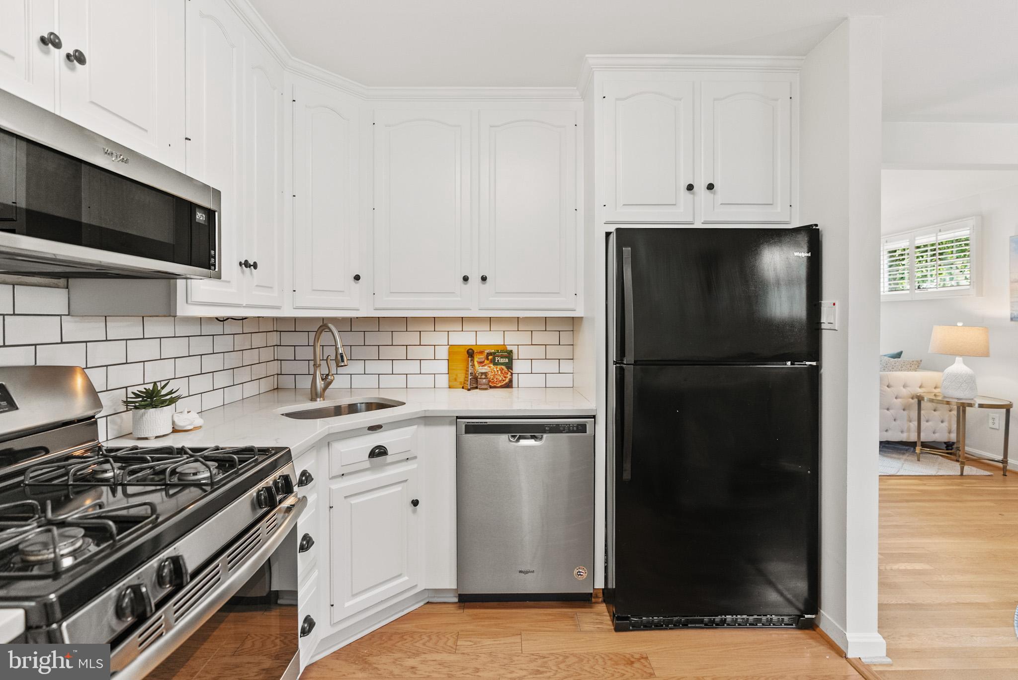4703 Wyaconda Road Rockville, MD 20852 - Photo 14 of 40 a kitchen with white cabinets and stainless steel appliances